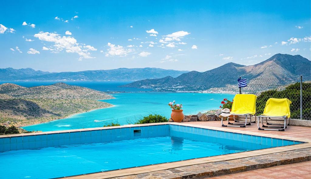 una piscina con vista sull'oceano di Villa Thea a Vrouchas