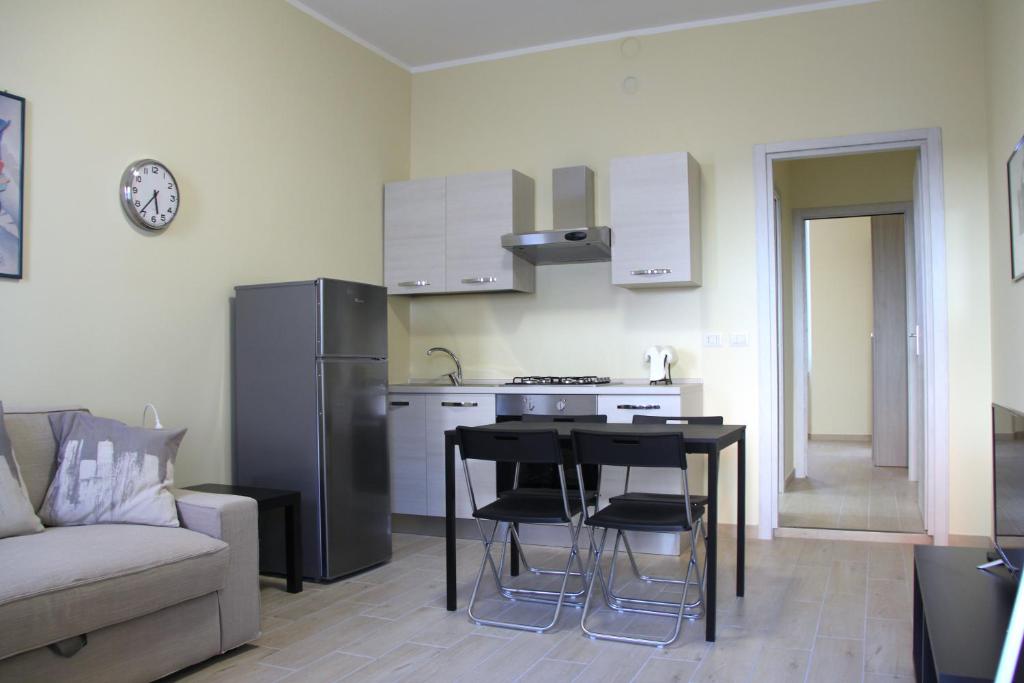a kitchen with a refrigerator and a table and chairs at Along the Canal smart flat Naviglio - 4 people in Corsico
