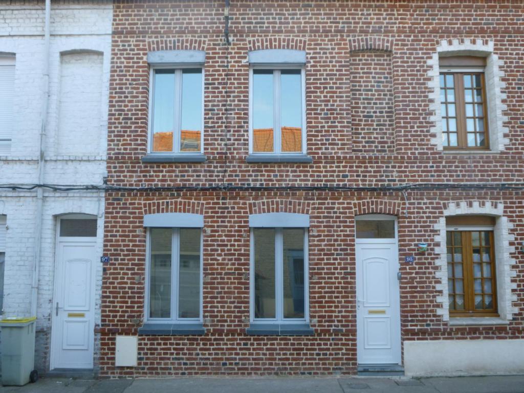 - un bâtiment en briques avec des portes et des fenêtres blanches dans l'établissement maison du haut pont, à Saint-Omer