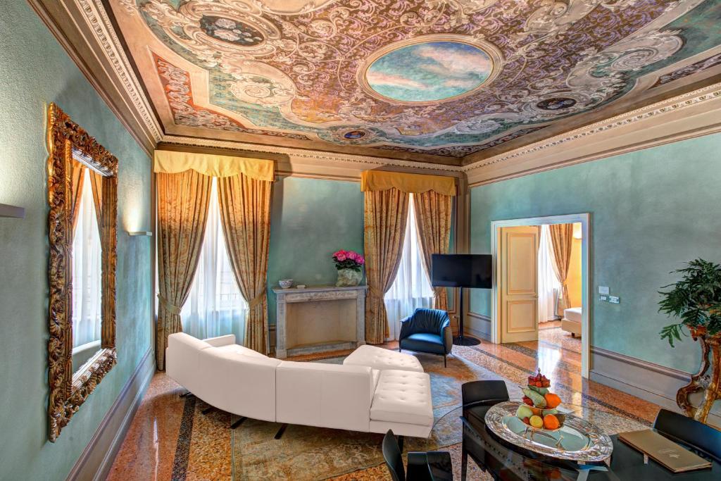 a living room with a white couch and a painted ceiling at Hotel Rua Frati 48 in San Francesco in Modena
