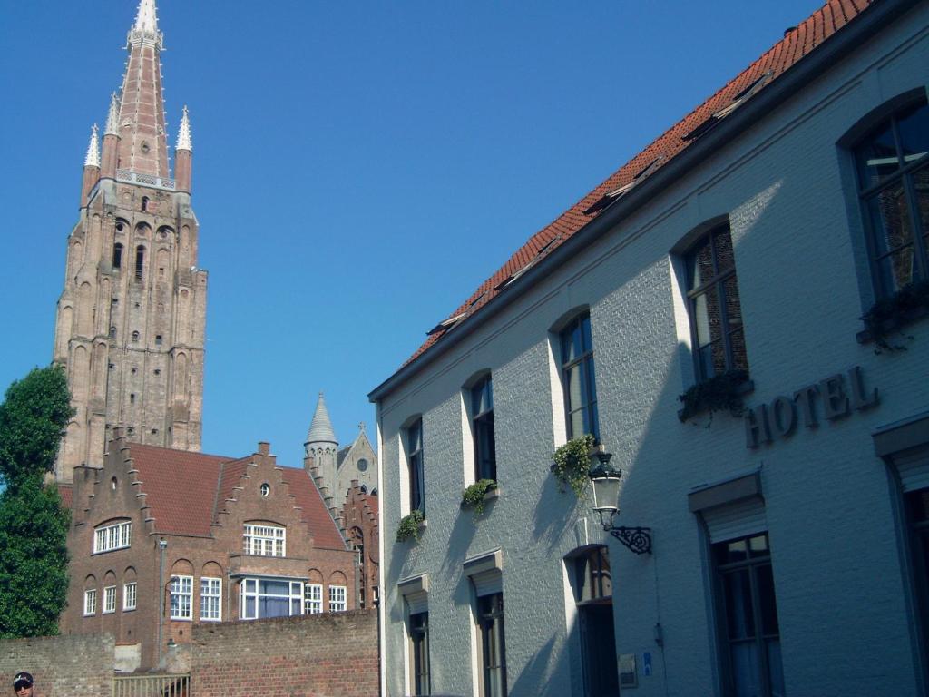 um grupo de edifícios com uma catedral ao fundo em Bonobo Apartments em Bruges