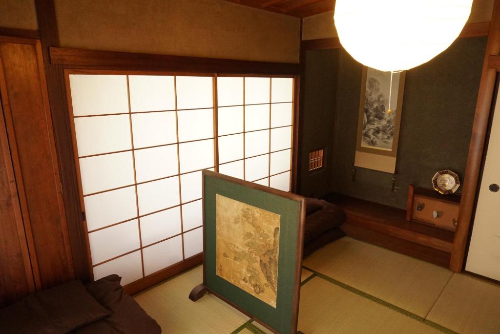 ein Wohnzimmer mit einem Gemälde vor dem Fenster in der Unterkunft Hostel Tomal in Kagoshima