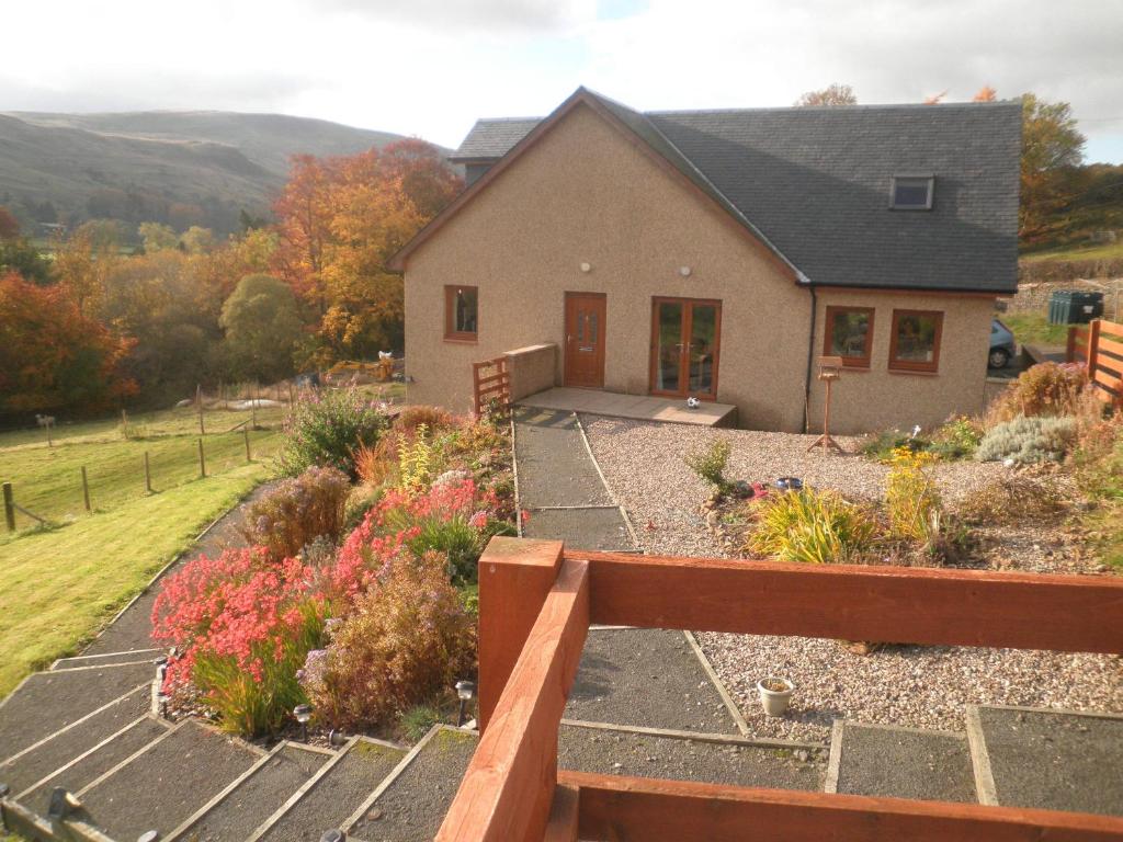 a house with a fence in front of a garden at Rockfoot B&B in Fintry