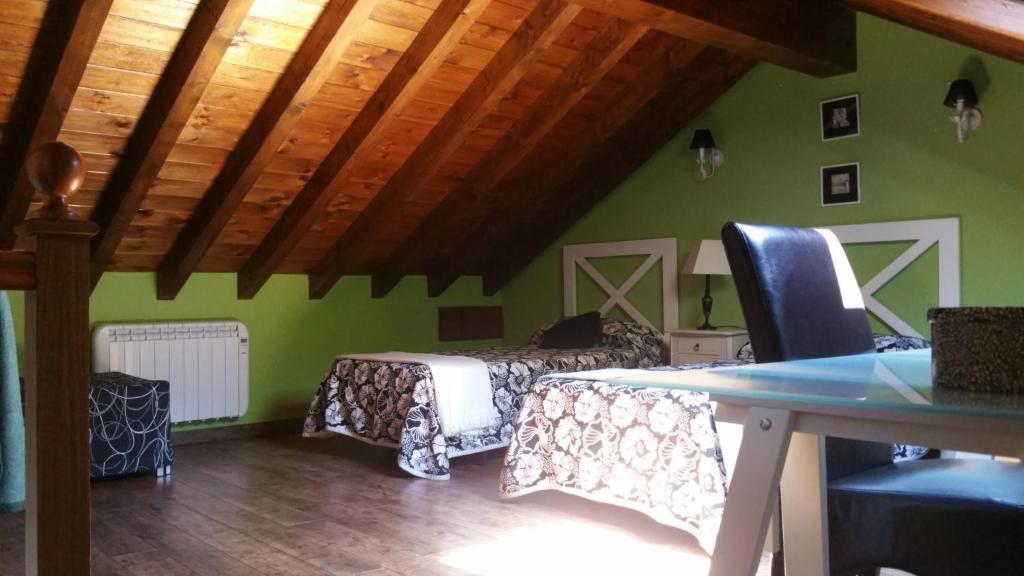 LAS VILLAS DEL PONTON في Trescares: غرفة نوم بجدران خضراء وسرير وطاولة