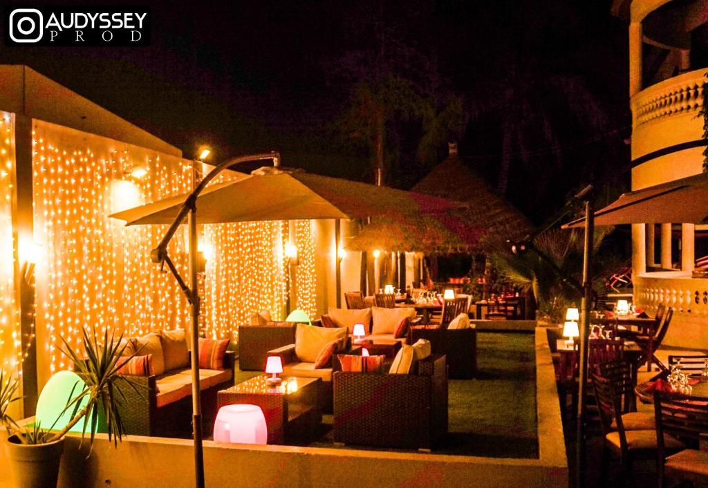 a patio with furniture and lights at night at La maison de celine in Dakar