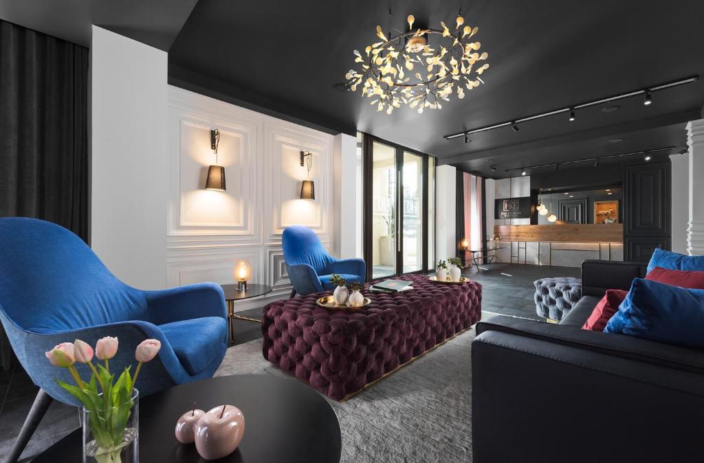 a living room with a couch and chairs and a chandelier at Hotel Del Corso in Timişoara