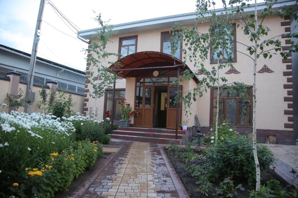 a house with a brick walkway in front of it at MEDI Guest House in Osh