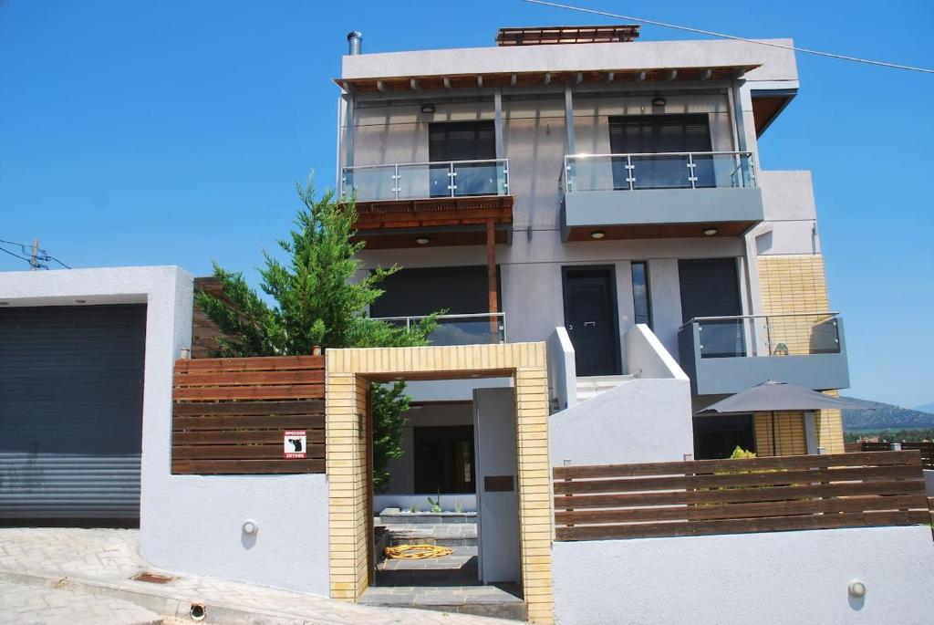 ein großes Haus mit einem Balkon und einem Zaun in der Unterkunft T&A Apartment,near the sea. in Marathón