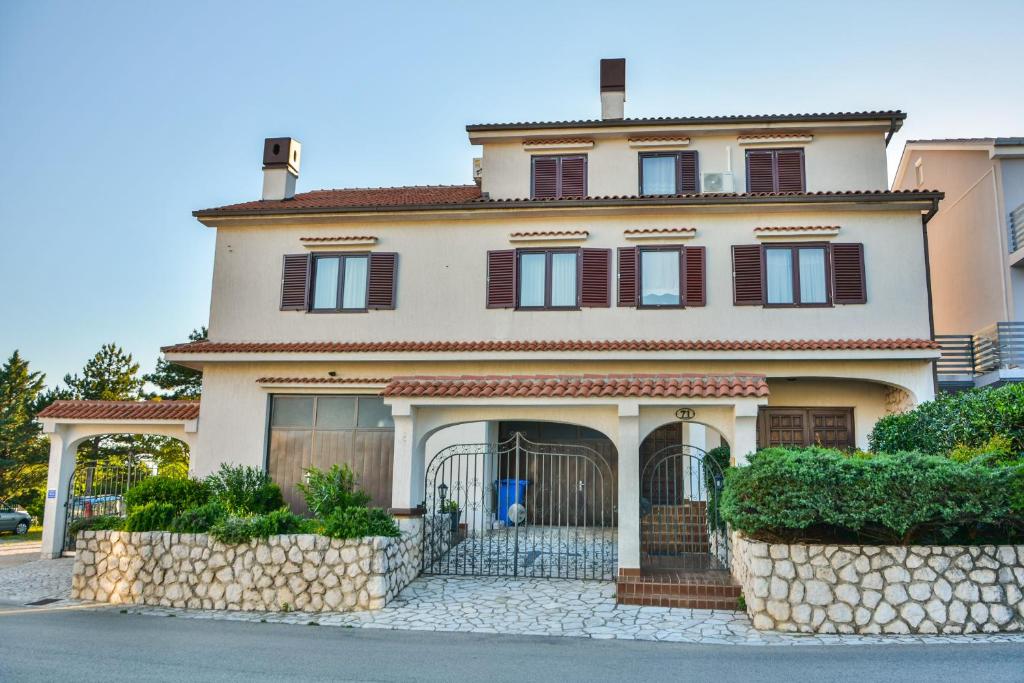 a large house with a fence in front of it at Bella Vista Apartments in Crikvenica