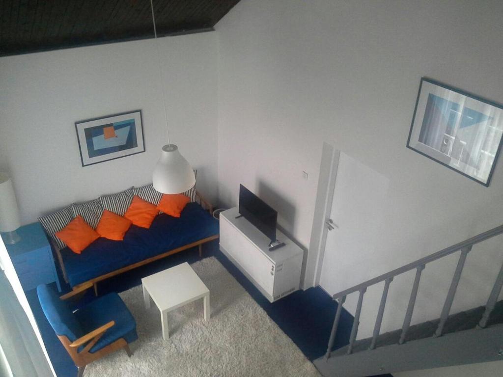 a living room with a blue couch with orange pillows at Casablanca in Herceg-Novi