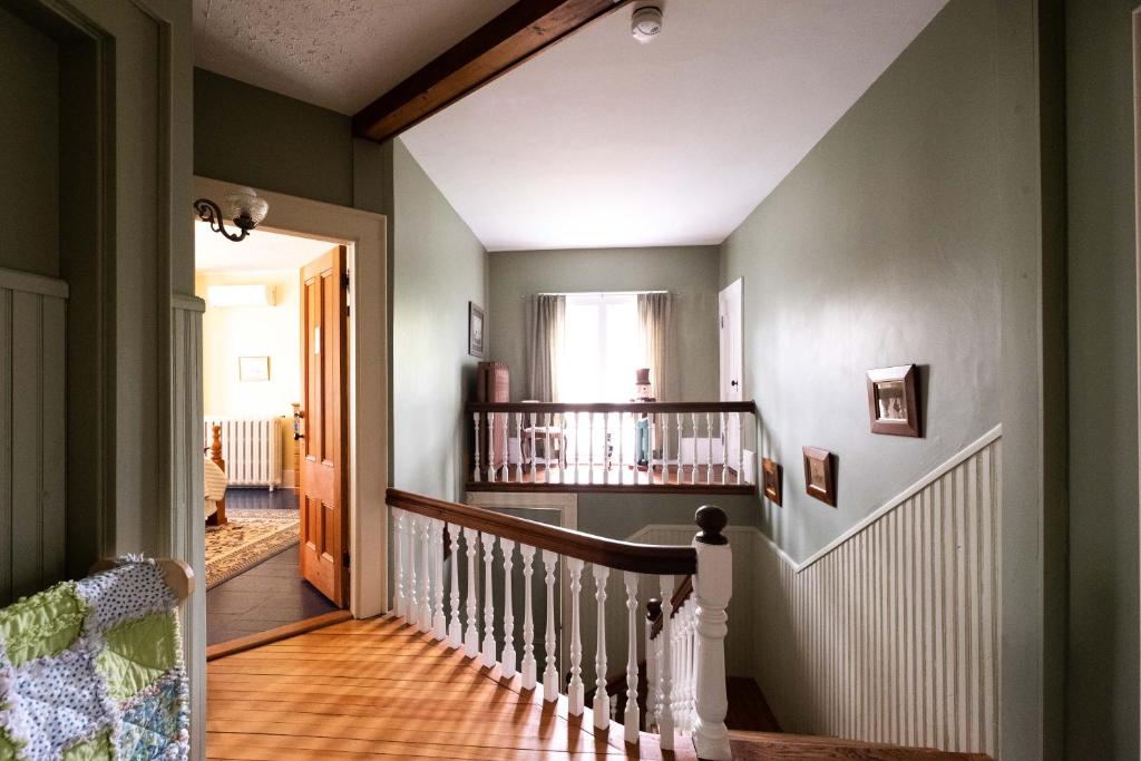 a hallway with a stairway with a stair railing at The Lark & Loon Inn in Annapolis Royal