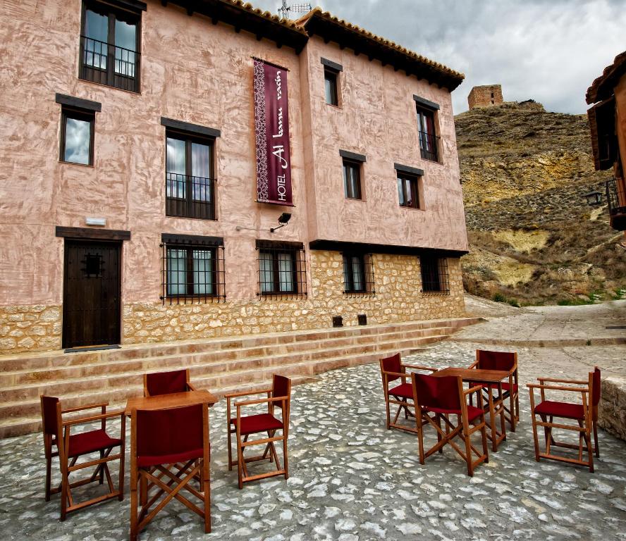 a group of chairs and tables in front of a building at Hotel Albanuracín in Albarracín