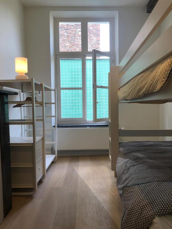 a bedroom with two bunk beds and two windows at Bed & Boon in Ghent