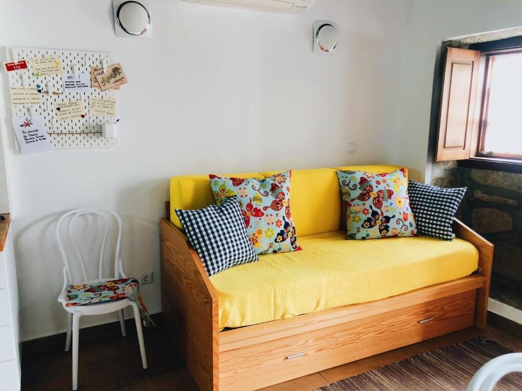 Domus Avocat في فالينسا: أريكة صفراء في غرفة مع كرسي