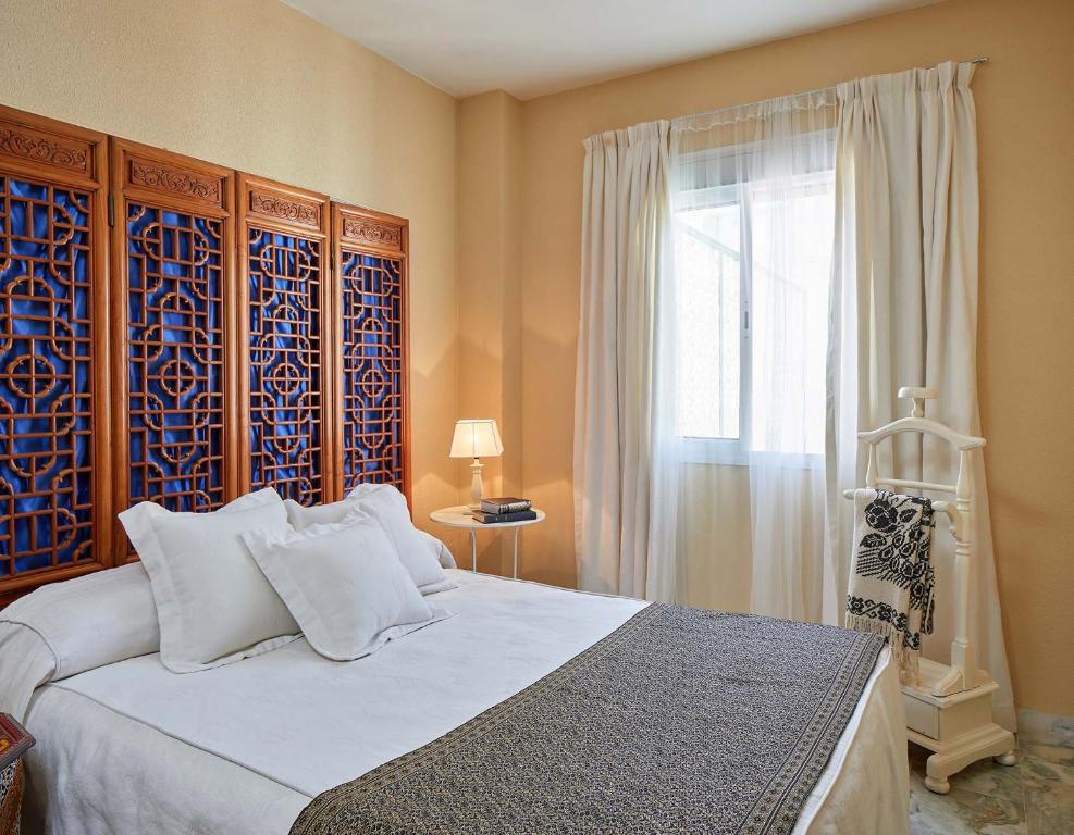 Un dormitorio con una cama grande y una ventana en El Rico Rincón de Sanlúcar la Mayor, en Sanlúcar la Mayor