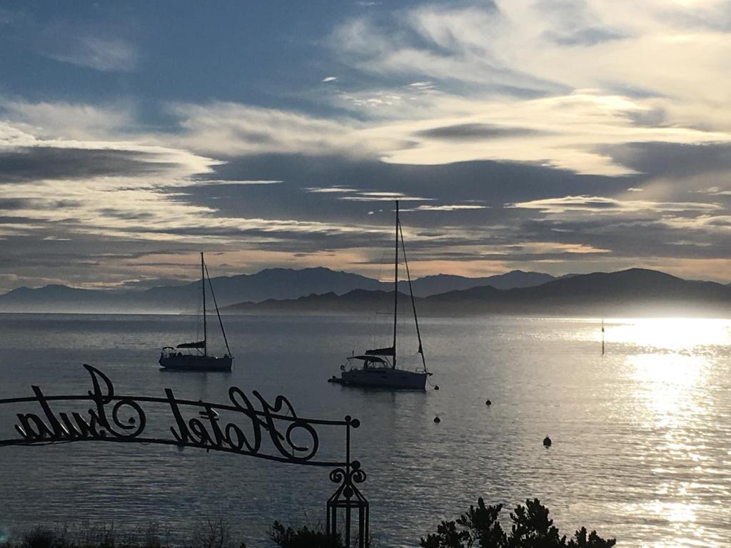 due barche in acqua con il sole sullo sfondo di L'Isula Rossa a LʼÎle-Rousse