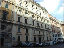 a large white building with cars parked in front of it at Hotel Texas in Rome