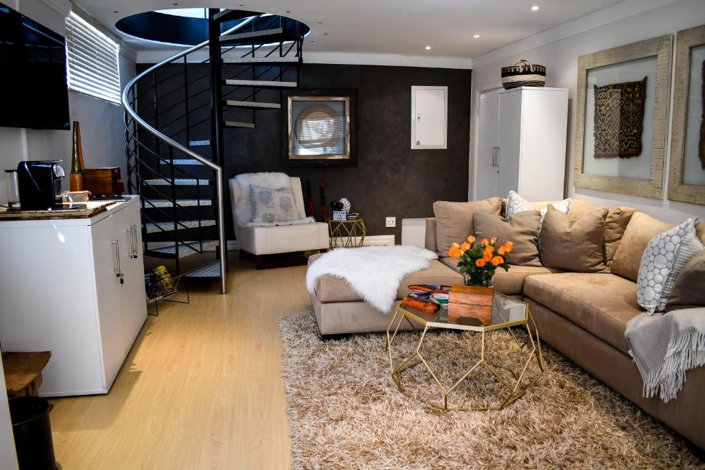 a living room with a couch and a spiral staircase at 20 ON WOODLANDS in Johannesburg