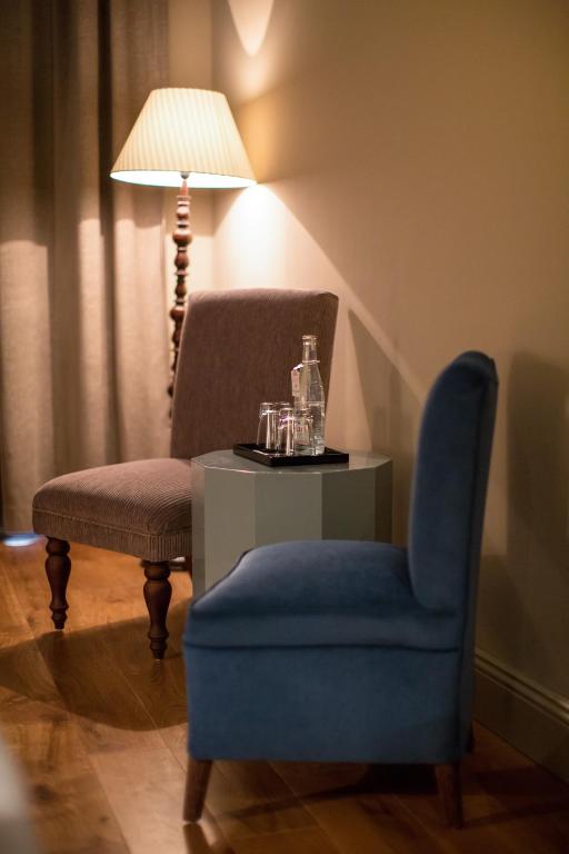 a room with a chair and a table and a lamp at Monbijou Hotel in Berlin