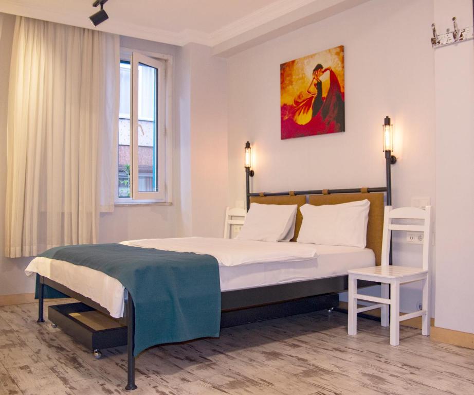 een slaapkamer met een bed en een schilderij aan de muur bij Hot Budget Ortakoy in Istanbul