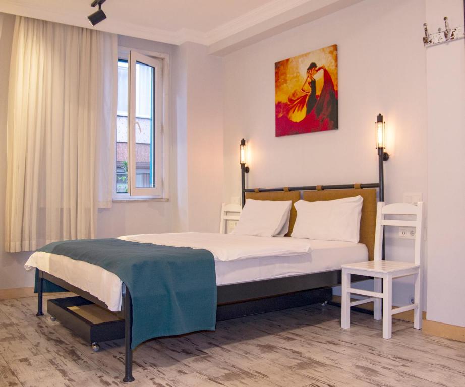 1 dormitorio con 1 cama y una pintura en la pared en Hot Budget Ortakoy, en Estambul