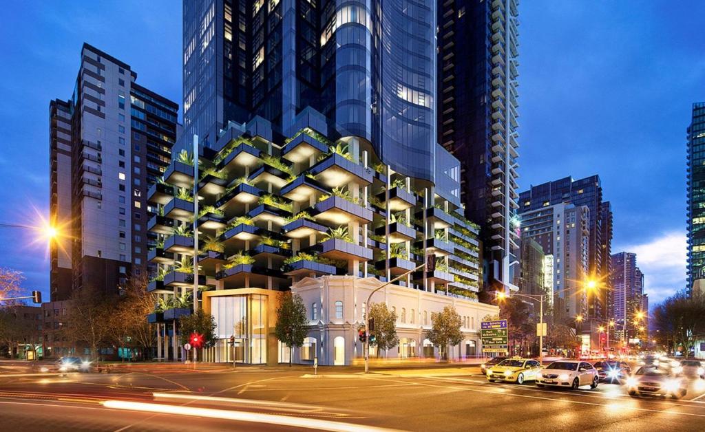 a tall building with cars parked in a city at CLLIX Australia 108 Apartments in Melbourne