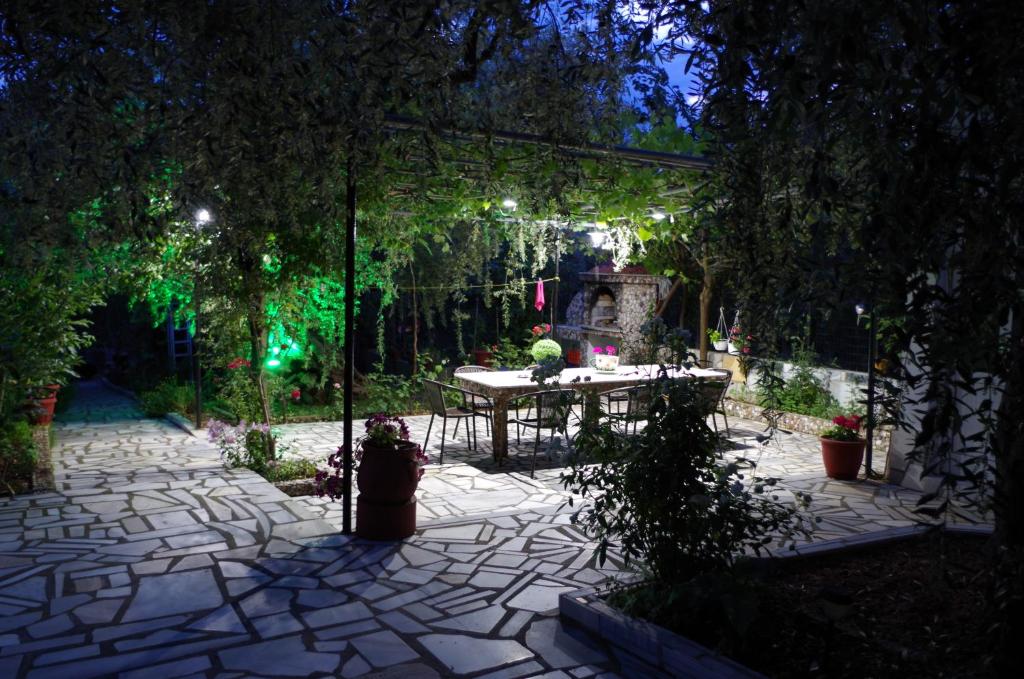 a patio with a table in a garden at night at Garden Guesthouse in Skala Kallirachis