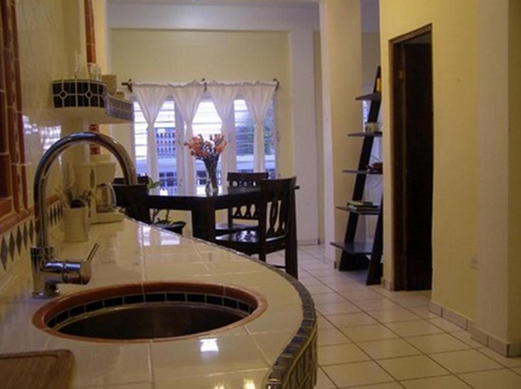 a kitchen with a sink and a dining room at Posada Colonial Beach Villas in San Juan