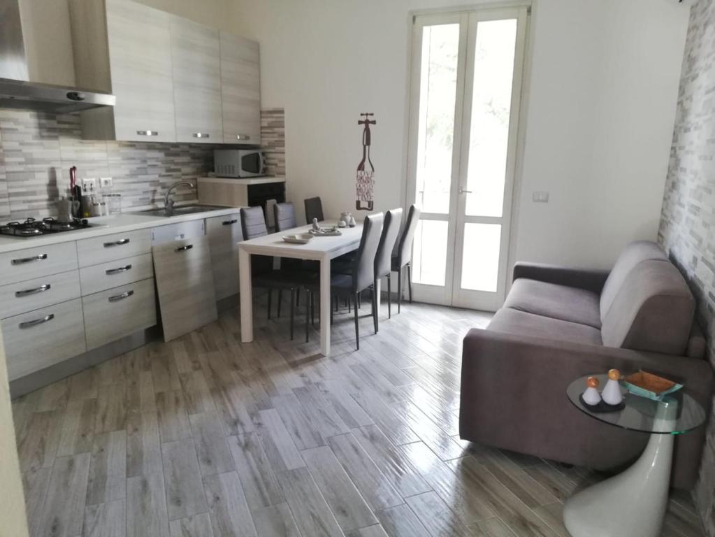 a kitchen and living room with a couch and a table at Casa di Mena in Alghero