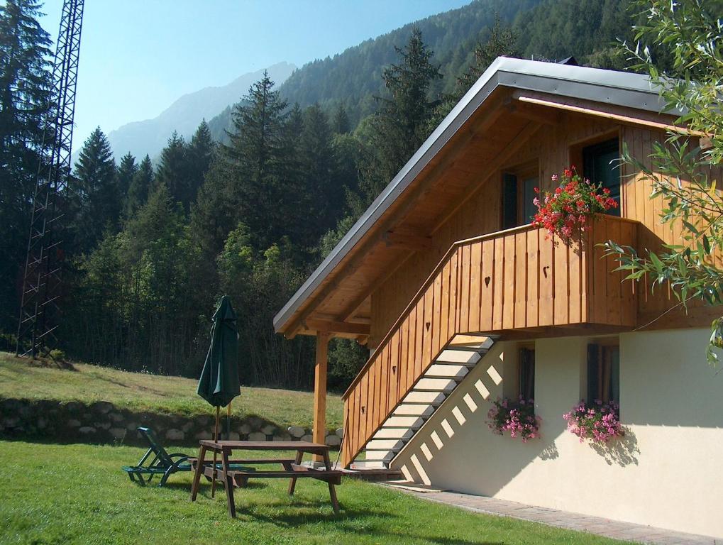 a building with a picnic table and a balcony at Chalet Presanella in Temù