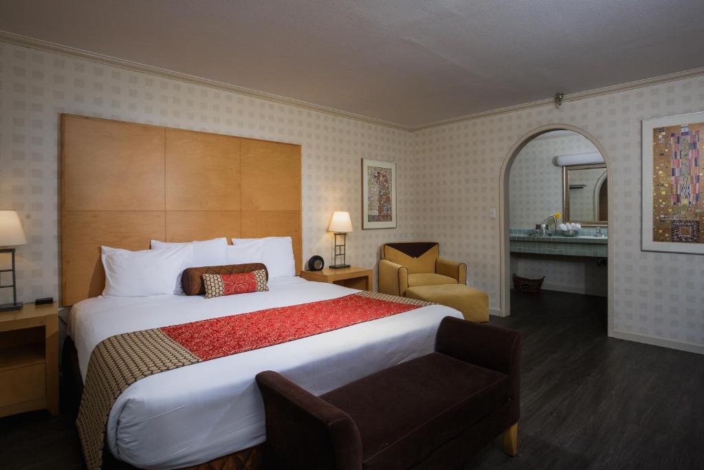 una habitación de hotel con una cama grande y una silla en Menlo Park Inn, en Menlo Park