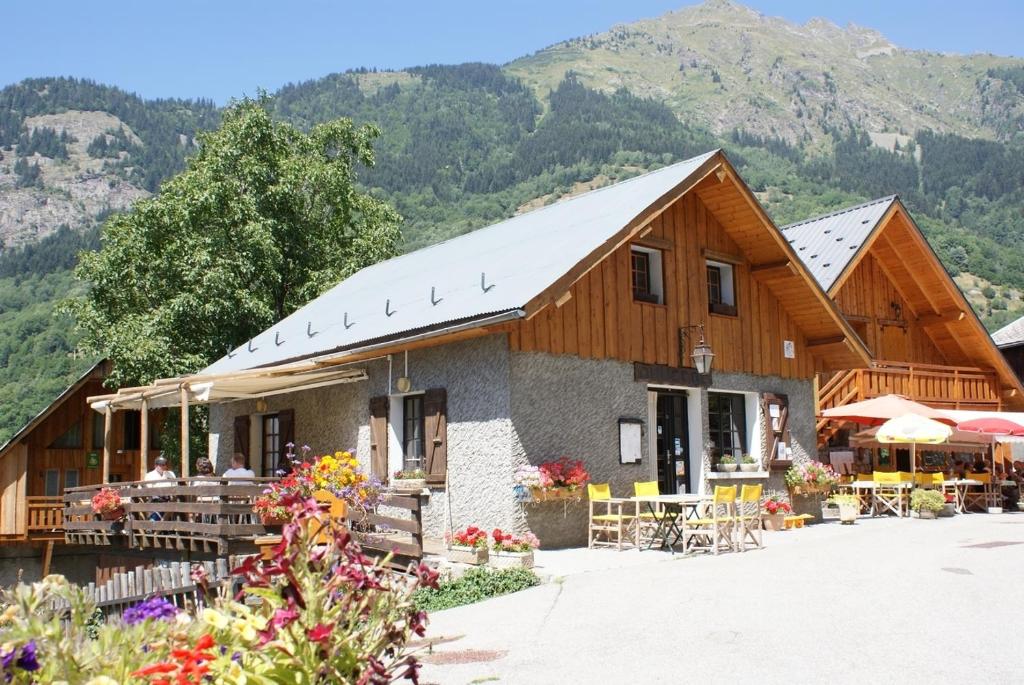 un bâtiment avec des montagnes en arrière-plan dans l'établissement Chez Passoud, à Vaujany