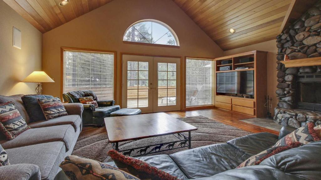 a living room with couches and a table and a fireplace at Mt. Hood 06 in Sunriver