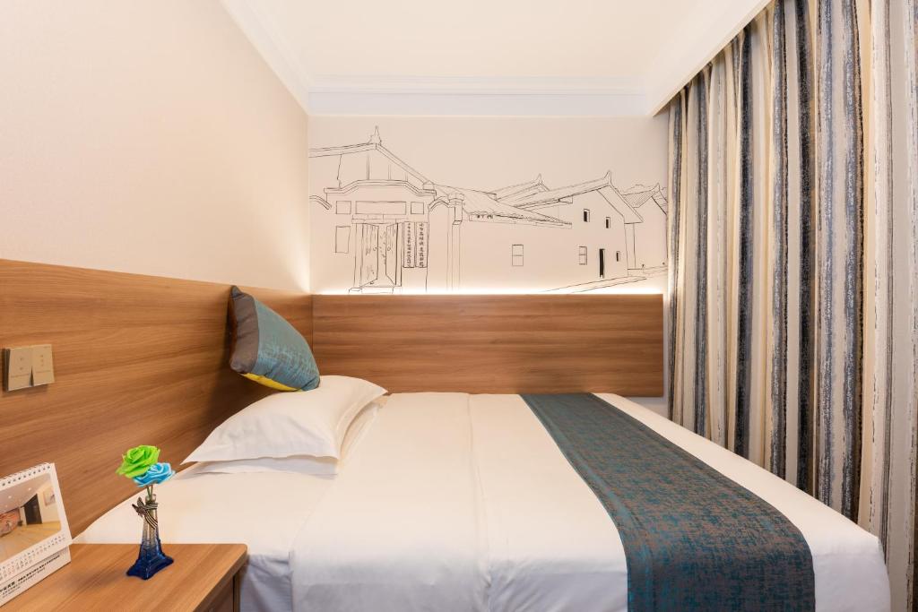 北京市にあるZhong An Hotel Beijing Former Residence of Journalist Edgar Snow -Free laundry service,Free freshly ground coffee,Provide tourism and ticketing service ,English service ,Near Tian'AnMen Forbidden City,Wangfujing walking streetのベッドルーム1室(壁に絵画付)