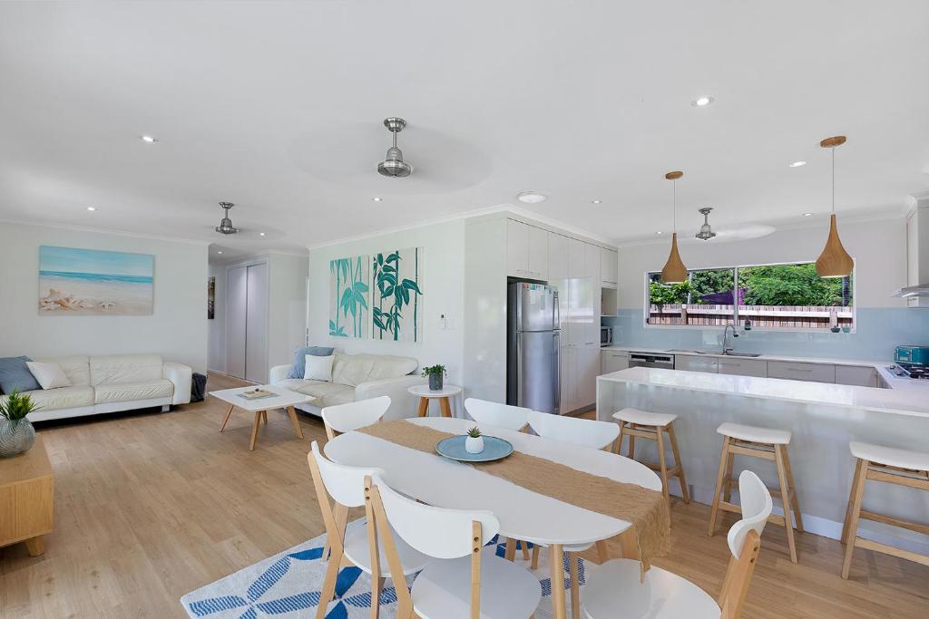 een keuken en een woonkamer met een tafel en stoelen bij Whitsunday Palms by HamoRent in Airlie Beach