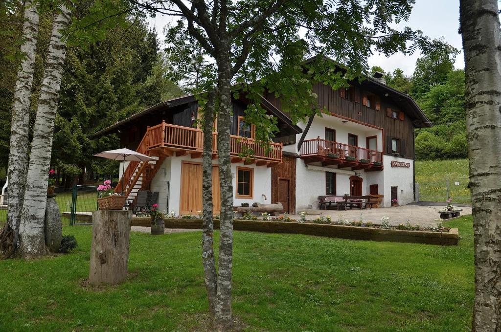 una casa en medio de un patio con árboles en Maso Kofler, en Rumo