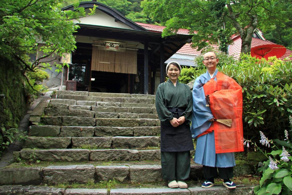 a man and woman in kimonos standing in front of a building at Shukubo Kansho-in Temple Sanrakuso in Daisen