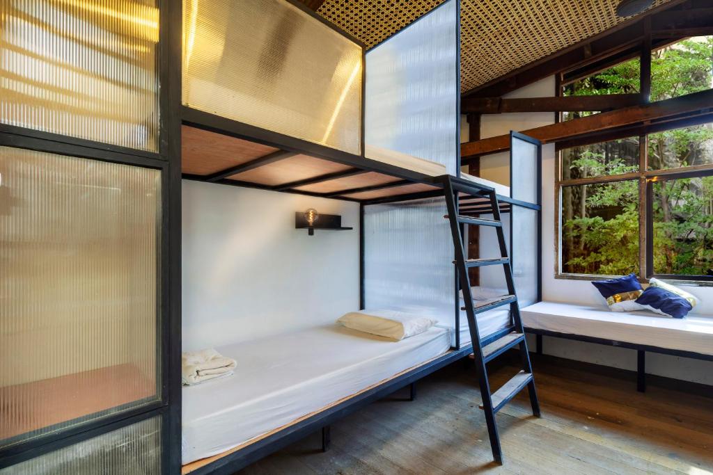 a room with two bunk beds and two windows at The Flying Fish Hostel Cebu in Cebu City