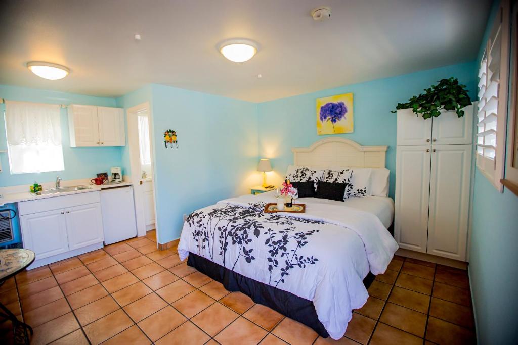 a bedroom with a white bed and white walls at Leucadia Beach Inn in Encinitas