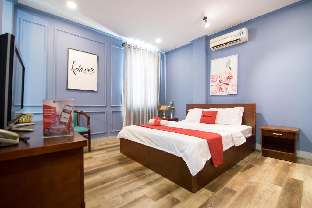 - une chambre avec des murs bleus, un lit et un bureau dans l'établissement Phuong Thuy Hotel Thu Duc near QL13, à Hô-Chi-Minh-Ville