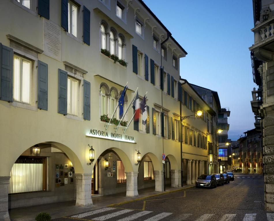 um edifício com bandeiras ao lado de uma rua em Astoria Hotel Italia em Udine