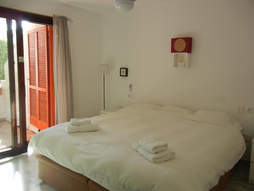 エステポナにあるVillacana 31/17のベッドルーム1室(白いベッド1台、タオル付)
