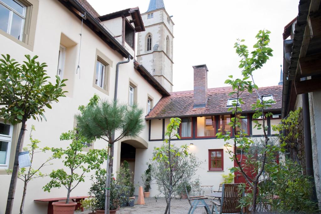 un patio en una casa con una iglesia al fondo en Wenkheimer Hof Ferienwohnung, en Iphofen