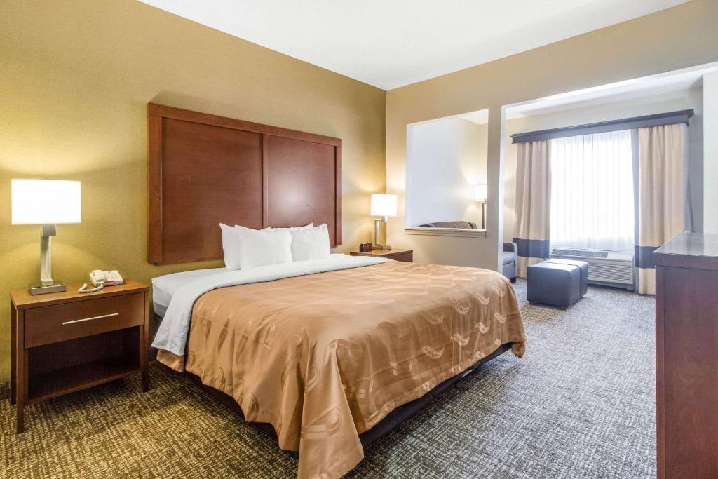 a hotel room with a bed and a large window at Quality Suites in Corbin