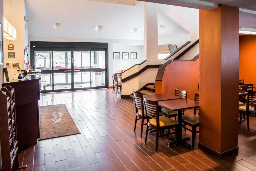 a restaurant with a table and chairs and a staircase at Quality Inn Bridgeport-Clarksburg in Bridgeport