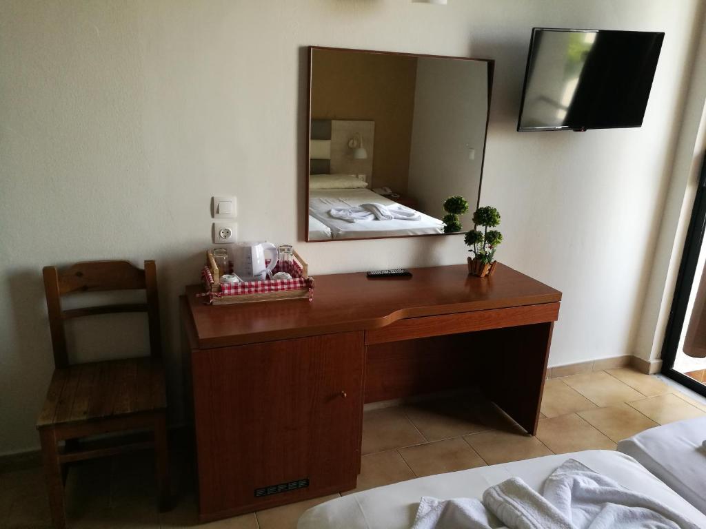 a bedroom with a desk with a mirror and a bed at Golden days in Afantou