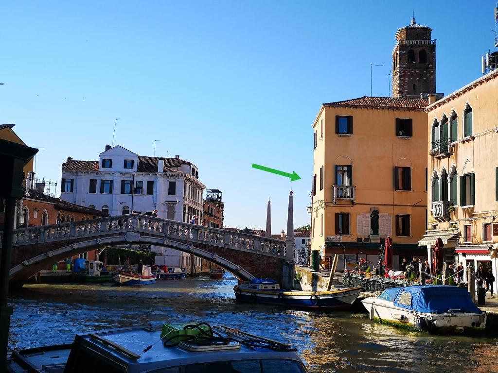 a bridge over a river in a city with boats at Guglie Palace in Venice