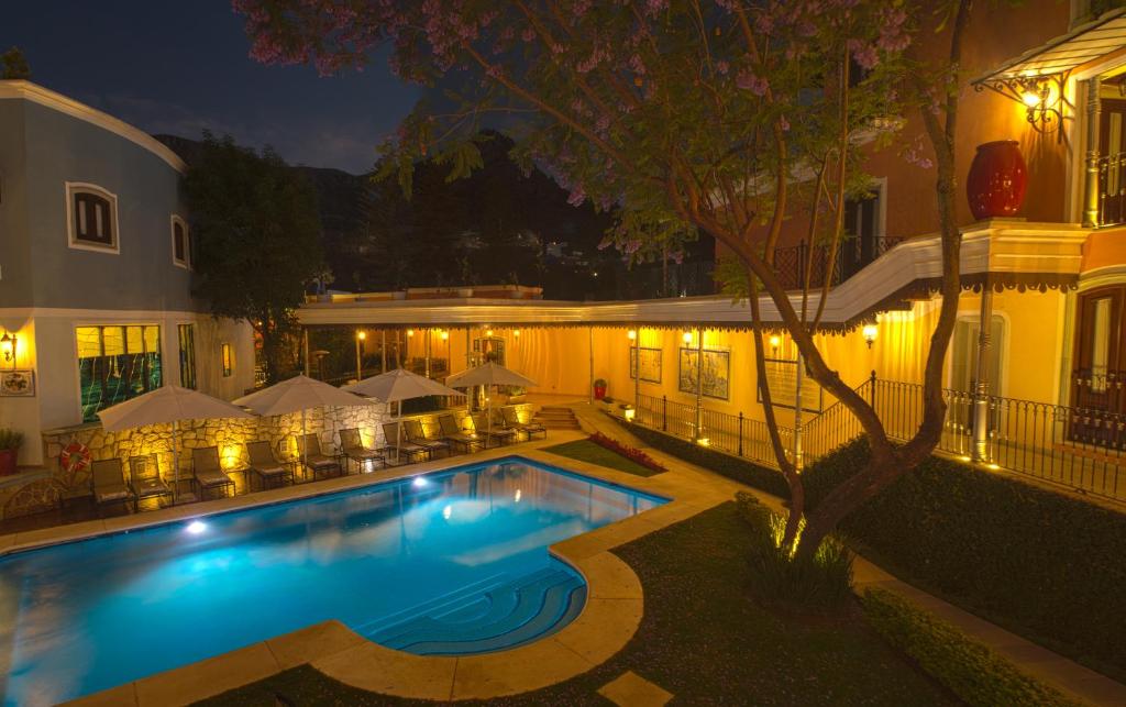 a swimming pool in front of a building at night at Villa Maria Cristina Hotel in Guanajuato