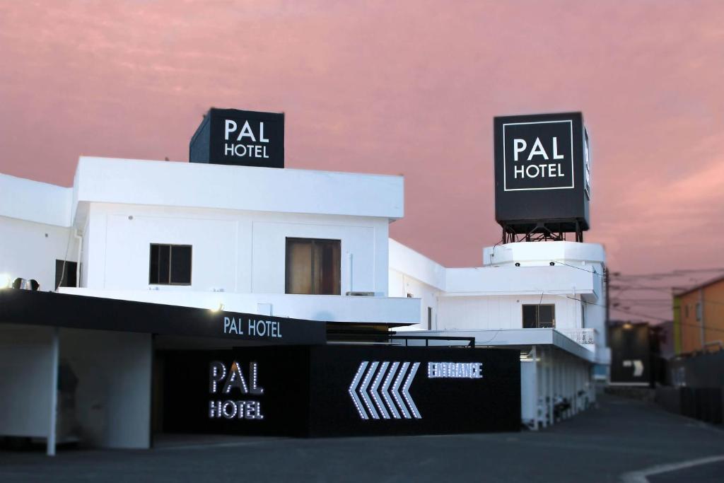 un edificio blanco con dos letreros encima en Munakata Pal (Love Hotel), en Munakata