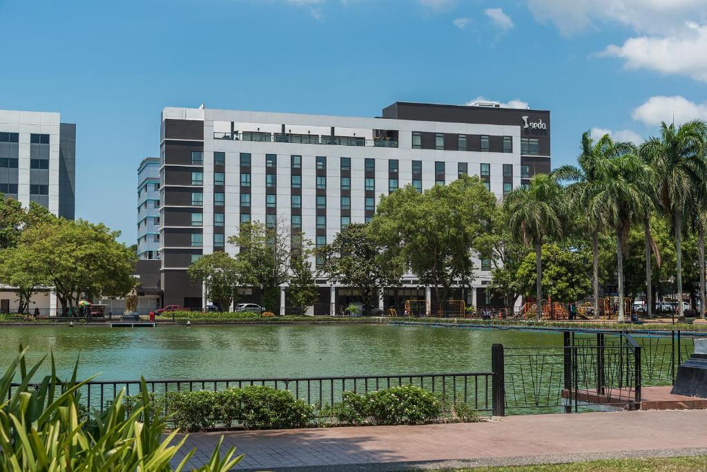 a large pond in front of a large building at Seda Capitol Central Hotel in Bacolod